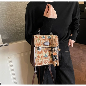 Close-up of vintage quilted backpack with metal lock and cute rabbit charm detail