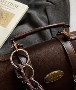 Close-up van bruine vintage kunstleertextuur met gouden handmade gesp op de handtas