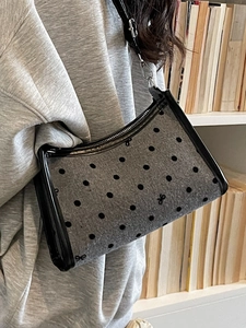Polka dot felt underarm bag with bow print and adjustable strap shown on model
