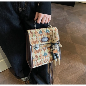 Detail of vintage rhombic pattern backpack with leather handle and cute rabbit charm