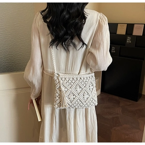 Detailed texture of white macrame crossbody bag with tassels and diamond weave pattern