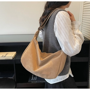 Détail du sac dumpling beige avec bandoulière réglable et logo Fashion sur cuir mat