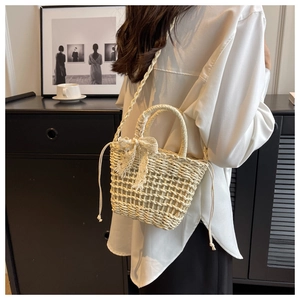 Detail showing handwoven texture with lace bow and drawstring closure on straw bag
