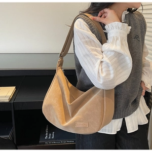 Détail du sac hobo kaki avec bandoulière réglable et étiquette mode sur toile mate