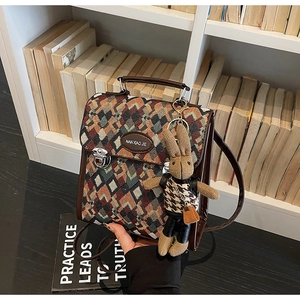 Detail of rhombic lattice textured bag with silver lock and plush bunny charm