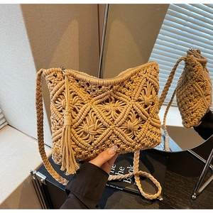 Detail of handmade macrame straw beach bag with floral woven patterns and long fringe tassels