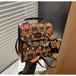 Detailed close-up of woven rhombus pattern backpack with leather accents and rabbit charm