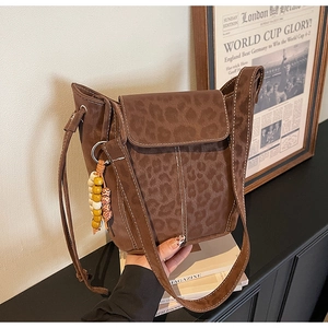 Detail of leopard print suede bucket bag with decorative colorful bead tassel