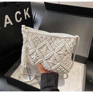 Detail of bohemian white woven shoulder bag with fringe tassel in a black premium gift box