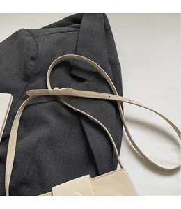 Détail du sac à bandoulière beige montrant le cuir lisse et la sangle réglable