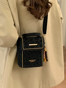 Chic black leopard print crossbody bag with gold rivets and beaded charm decoration