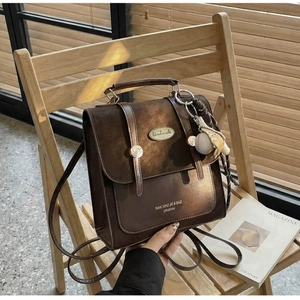 Detail van vintage donkerbruine rugzak met metalen gesp en handgemaakte metalen plaat