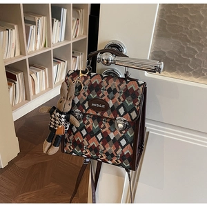 Detail of retro quilted backpack with colorful woven pattern and cute rabbit charm