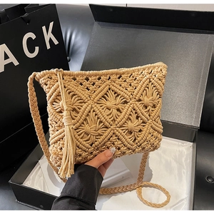 Detailed view of woven diamond pattern and tassel on cotton straw crossbody bag