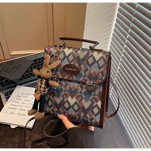 Detail of retro geometric woven pattern bag with leather handle and rabbit charm