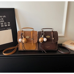 Retro crossbodytassen in bruin en beige met baseball-hangers en metalen logo's