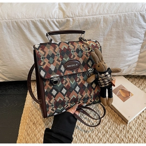 Detail of woven lattice handbag with leather handle and cute rabbit charm on a straw mat