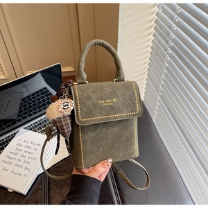 Detailed view of green microfiber handbag with gold rivets and ice cream charm