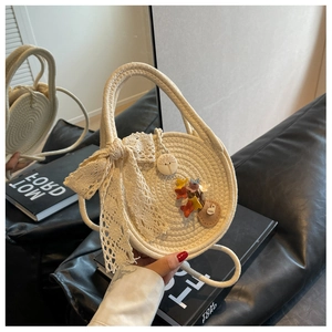 Detailed macro of beige straw bag with lace bow and colorful 3D flower floral patches