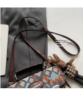 Gros plan détaillé du sac bandoulière en tissu matelassé avec bordure en cuir marron