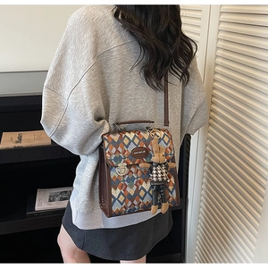 Detail of rhombic quilted crossbody bag with metal buckle and plush rabbit charm