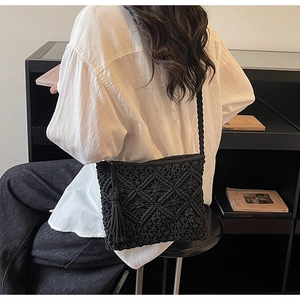 Detail of black handmade woven crossbody bag with fringe tassel and diamond texture