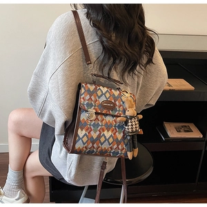 Detail of colorful quilted woven backpack with brown PU straps and a cute rabbit pendant
