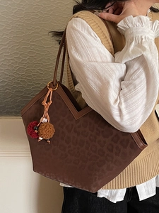 Large leopard print tote bag with V-shaped opening and decorative fur pompom charm