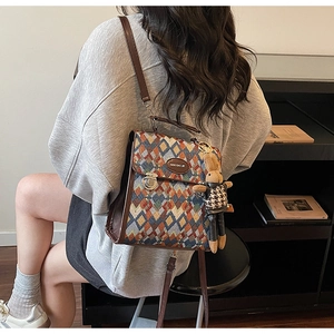 Detail of vintage quilted backpack with leather trim and decorative bunny charm