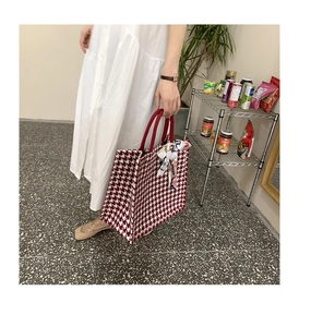 Detail of red and white houndstooth tote bag featuring a silk scarf and circular handles