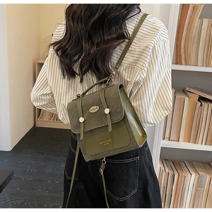Detail van donkergroene vintage crossbody tas met gesp en handgemaakte metalen zegel