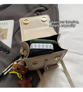 Detailed interior view of beige crossbody bag with magnetic buckles and large capacity