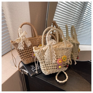 Detailed view of handmade straw bags with lace bows and 3D floral accents in two colors