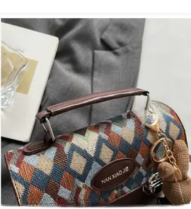 Détail d'un sac tissé matelassé coloré avec poignée en cuir et charm ours peluche