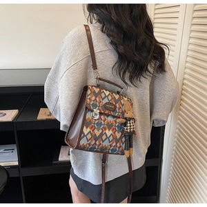 Detail of colorful geometric lattice backpack with brown leather strap and rabbit charm