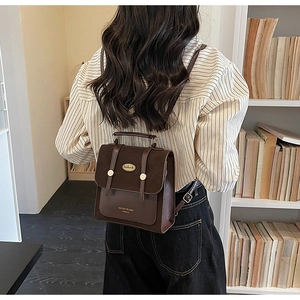 Detail van vintage bruine PU-lederen handtas met gesp, verstelbare riemen en handgrepen