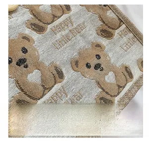 Close-up of woven fabric showing Happy Little Bear patterns and detailed texture
