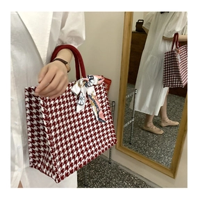 Close-up of red houndstooth tote bag featuring a decorative scarf and mirrored view