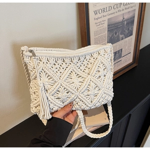 Macro shot of white handmade macrame shoulder bag with fringe detail and zipper