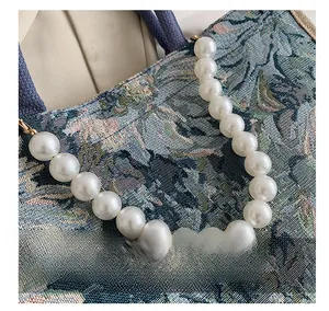 Detail showing the white pearl handle and vintage jacquard fabric with floral patterns