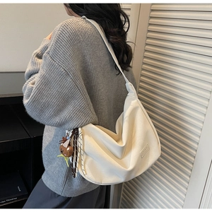 Détail du grand sac hobo crème avec breloque ours et étiquette en cuir FASHION