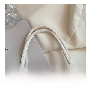 Detail of sturdy cream cotton rope handles on a stylish jute canvas lunch bag