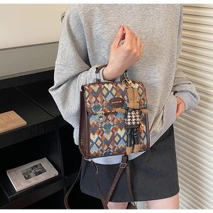 Detail of woven diamond pattern crossbody bag with metal lock and rabbit charm