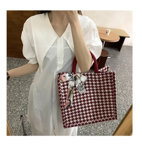 Detail of red houndstooth tote bag with printed silk scarf on handle and large capacity