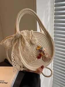 Stylish round straw beach bag with white lace bow and handmade floral detail