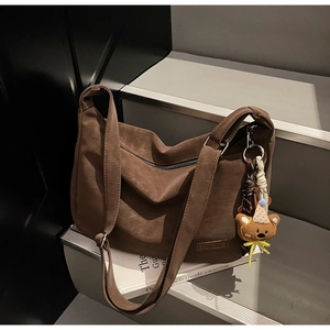 Gros plan du sac marron foncé rétro avec texture mate et pendentif en forme d'ours