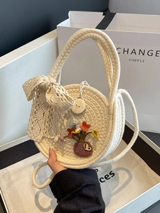 Handcrafted circular straw shoulder bag with lace bow and floral appliqués for beach