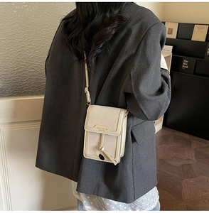 Vertical cream crossbody phone bag shown on a grey blazer for daily casual styling