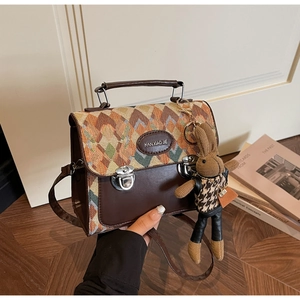 Détail du sac à main vintage en jacquard géométrique avec finitions en cuir marron
