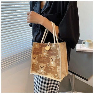 Detail of cute bear printed jute lunch bag with rope handles and wooden button closure